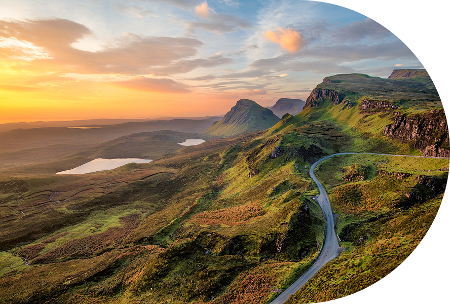 Scenic landscape with winding road and sunset.